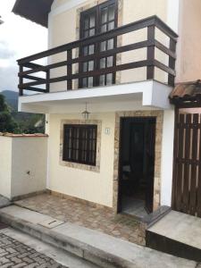 a house with a balcony on top of it at Chale Zen in Penedo