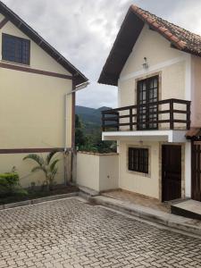 a white house with a balcony and a driveway at Chale Zen in Penedo