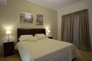 a bedroom with a large bed and two lamps at Mezapos Villa Katerina in Mézapos