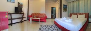 una camera con letto, sedia e TV di Rao Ga Khao Resort a Mu Si