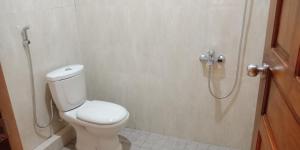 a bathroom with a toilet and a shower at Puri Agung Inn in Sidemen