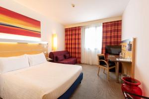 pokój hotelowy z łóżkiem i biurkiem z komputerem w obiekcie Best Western Palace Inn Hotel w mieście Ferrara