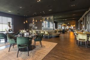 a restaurant with chairs and tables and a bar at Fletcher Kloosterhotel Willibrordhaeghe in Deurne