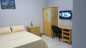 Schlafzimmer mit einem Bett und einem Schreibtisch mit einem TV in der Unterkunft Sunburst in Arnos Vale