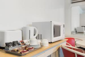 a kitchen counter with a microwave and a plate of food at Alexander Motor Inn in Melbourne