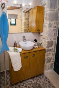 uma casa de banho com um lavatório e uma parede de pedra em ARISTIDIS'S PLOUTI MOIRES em Ploutí
