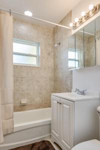 ein Badezimmer mit einem Waschbecken, einer Badewanne und einem Spiegel in der Unterkunft Meehan in Port Charlotte