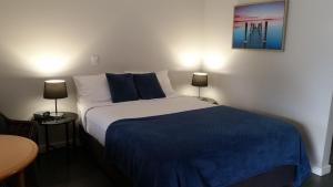 a bedroom with a bed and a lamp at Tweed River Motel in Murwillumbah