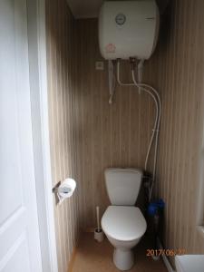 a small bathroom with a toilet and a water tank at Melluzi Cottage in Jūrmala
