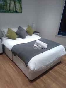 ein Bett mit zwei gewalzten Handtüchern darüber in der Unterkunft Clifton Apartment in Luton