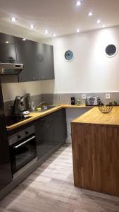 Chaleureux appartement au cœur du Panier في مارسيليا: مطبخ مع اجهزه سوداء وكاونتر خشبي