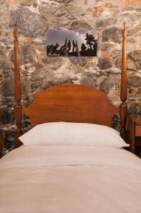 a bedroom with a bed and a stone wall at Casa Emblematica Amelia in Santa Cruz de la Palma