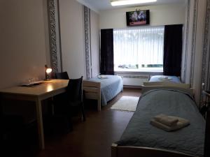 Schlafzimmer mit einem Bett, einem Schreibtisch und einem Fenster in der Unterkunft Sõrve Guest House in Salme