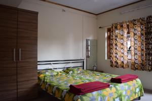 1 dormitorio con 1 cama, vestidor y ventana en SWAMI home stay panhala, en Panhāla