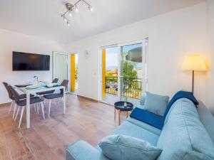 salon z niebieską kanapą i stołem w obiekcie Appartments Adriatic w mieście Omišalj
