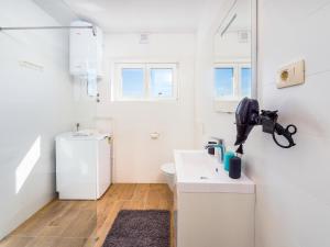 biała łazienka z umywalką i toaletą w obiekcie Appartments Adriatic w mieście Omišalj