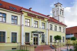 a large building with a clock on the front of it at Memel Hotel in Klaipėda