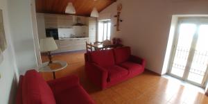 uma sala de estar com um sofá vermelho e uma mesa em Holiday House em Santa Severina