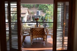 mesa y sillas en una habitación con ventana en SWAMI home stay panhala, en Panhāla