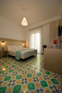 a bedroom with a bed and a tiled floor at Hotel Torre Di Milo in Maiori