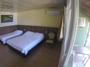 a bedroom with two beds and a chair in it at Rainbow Bay Ozdere Beach Hotel in Özdere