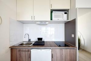 una piccola cucina con lavello e microonde di Sea Swing and Sun a La Ciotat