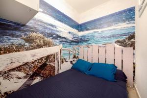 una camera da letto con un murale dell'oceano sul muro di Sea Swing and Sun a La Ciotat