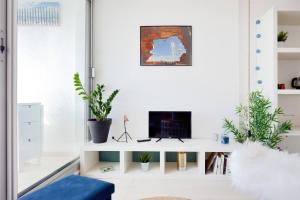 un soggiorno bianco con TV su una mensola bianca di Sea Swing and Sun a La Ciotat