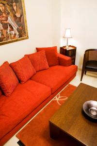 a red couch in a living room with a table at Melon Suites in Thessaloniki