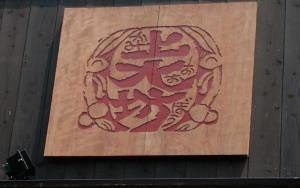 a wooden cutting board with a sign on it at Kamiobo in Kobe