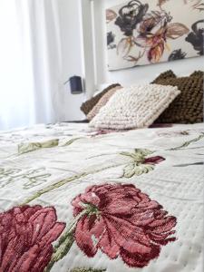 a bed with a flower quilt on top of it at Apartment Zrinjevac in Zagreb