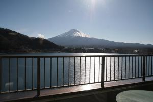 uma vista para uma montanha coberta de neve a partir de uma varanda em Tominoko Hotel em Fujikawaguchiko