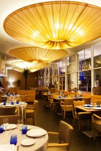 a restaurant with tables and chairs and a large ceiling at Atenea Port Barcelona Mataró in Mataró