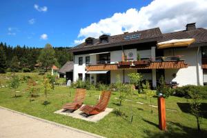 a house with a bunch of chairs in the yard at Gästehaus Seewald in Schluchsee