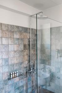 a bathroom with a shower with a glass door at Emelisse Nature Resort in Fiskardho