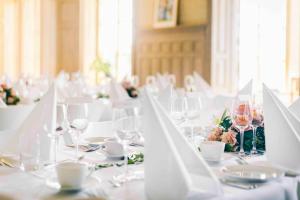 uma sala de jantar com mesas brancas e cadeiras com copos de vinho em Hotel J, Stockholm, a Member of Design Hotels em Nacka