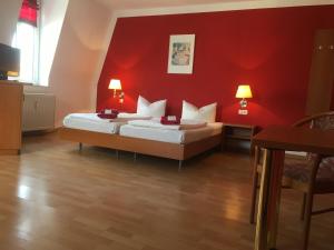 a bedroom with a white bed and a red couch at Hotel & Pension NOlift in Dresden