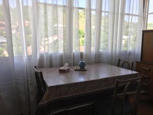 a table in front of a window with white curtains at Guest House Embroidery in Dilijan +12 photos