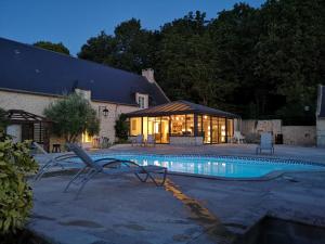 - une piscine en face d'un bâtiment avec une maison dans l'établissement Villa Gold Beach, à Saint-Côme-de-Fresné