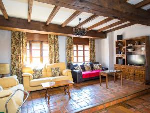 a living room with two couches and a tv at La Cancela Casa Rural in Fuente el Fresno