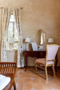 een slaapkamer met een bureau, een stoel en een spiegel bij Smadar-Inn in Zikhron Ya‘aqov