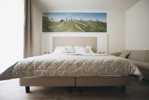 a bedroom with a bed with a picture on the wall at Cascina Speranza Hotel in Riva presso Chieri