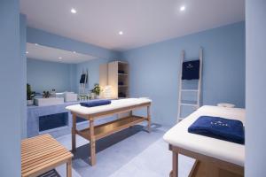 a blue room with two beds and a bathroom at Aloe Boutique Hotel & Suites - adults only in Almirida
