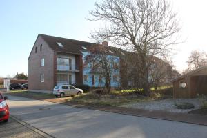 a house with a car parked in front of it at Haus Marinus in Puttgarden