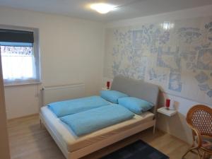 a bedroom with a bed with blue pillows on it at Ferienwohnung Morgensonne in Bad Schandau