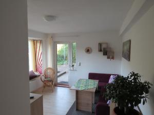 uma sala de estar com um sofá roxo e uma mesa em Ferienwohnung Morgensonne em Bad Schandau