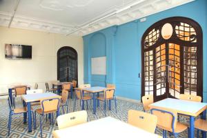 una clase con mesas y sillas en una sala con paredes azules en Alberg El Masnou Xanascat, en Teià