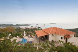 a house with an orange roof and a swimming pool at Villa Fotini in Skiathos