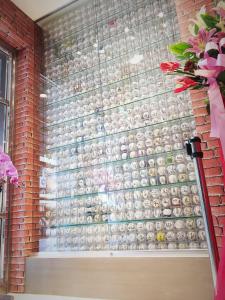 une fenêtre avec un bouquet de vases sur un mur de briques dans l'établissement La Hotel-Baseball Theme Hall, à Kaohsiung