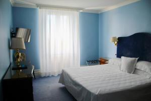 a blue bedroom with a bed and a window at Hotel Riviera & Maximilian's in Trieste